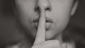 Eine Frau legt den Finger an die Lippen