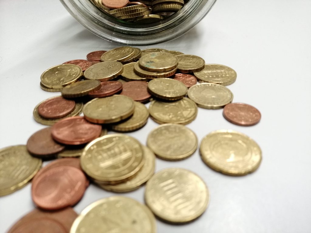 Münzen geringen Wertes, die aus einem Glas geschüttet wurden