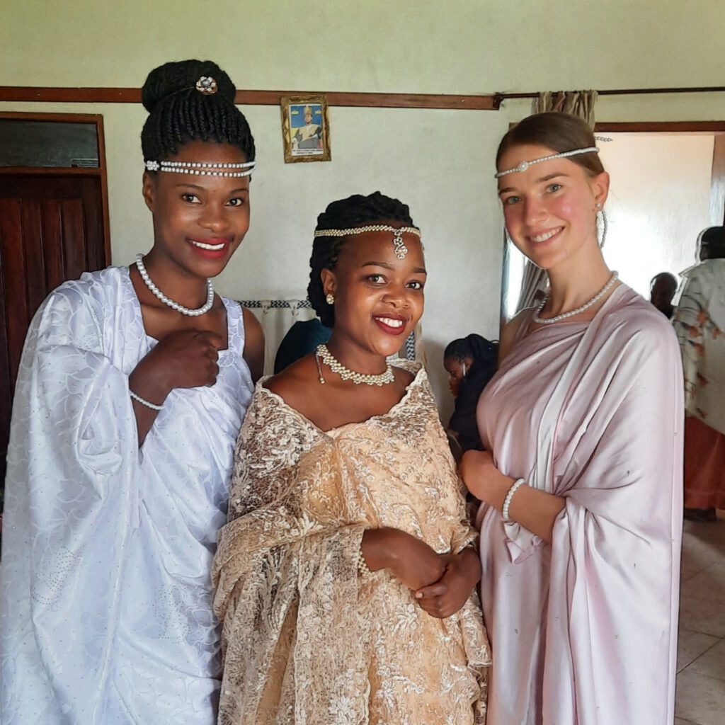 Christin und zwei einheimische Frauen lächeln in traditioneller Kleidung in die Kamera