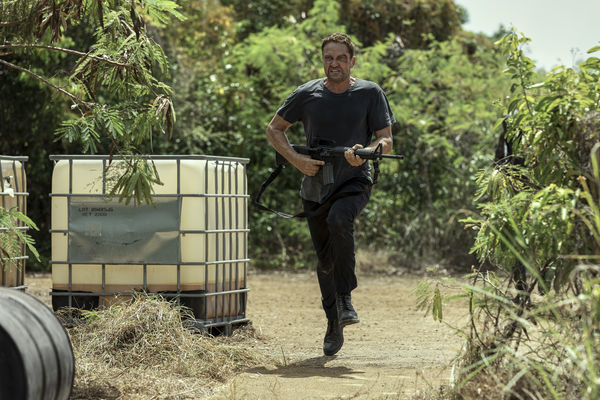 Mann mit Gewehr rennt durch Dschungel