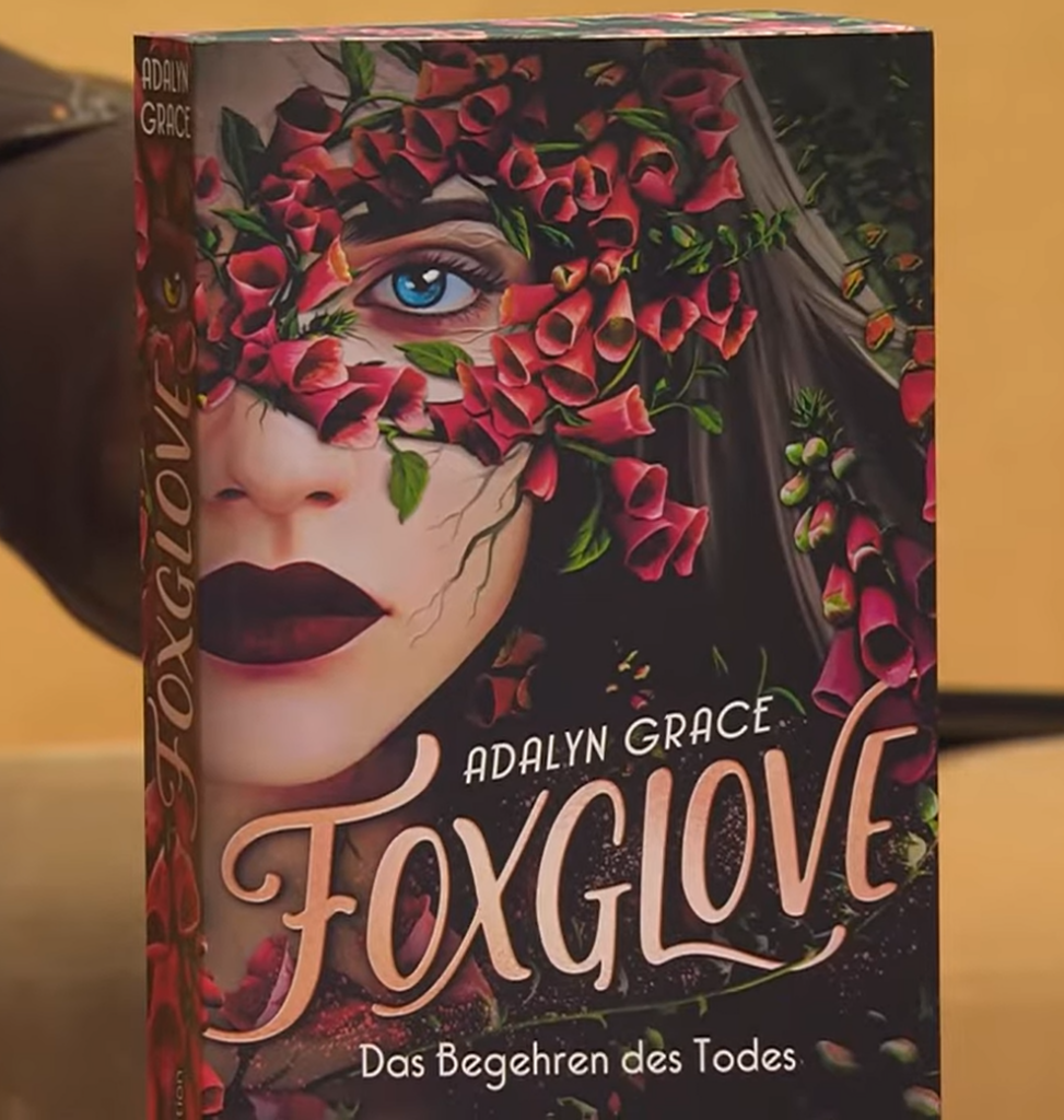 Roman "Foxglove - Das Begehren des Todes" von Adelyn Grace auf einem Tisch